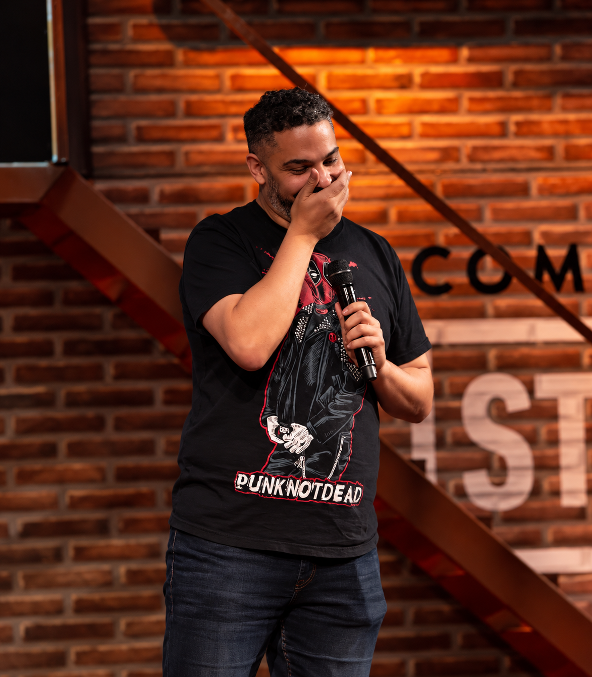 Ricardo Bisignano riéndose con el micrófono en el escenario